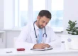 Healthcare provider reviewing revenue cycle documentation at a clinical desk illustrating RCM administrative challenges facing US hospitals in 2026.