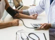 Doctor measuring patient blood pressure during a medical checkup in a clinic