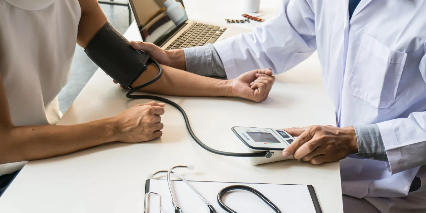 Doctor measuring patient blood pressure during a medical checkup in a clinic
