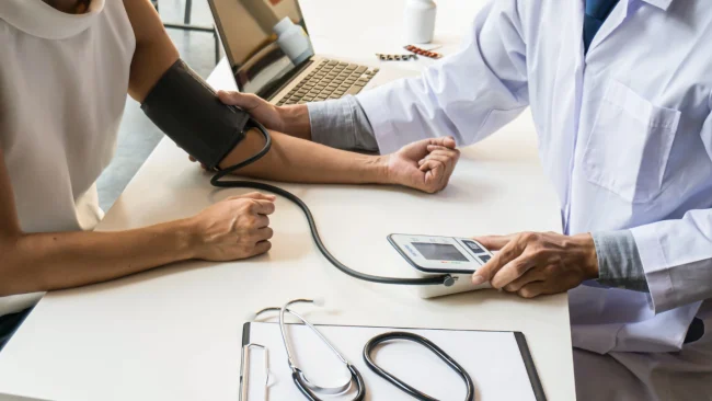 Doctor measuring patient blood pressure during a medical checkup in a clinic