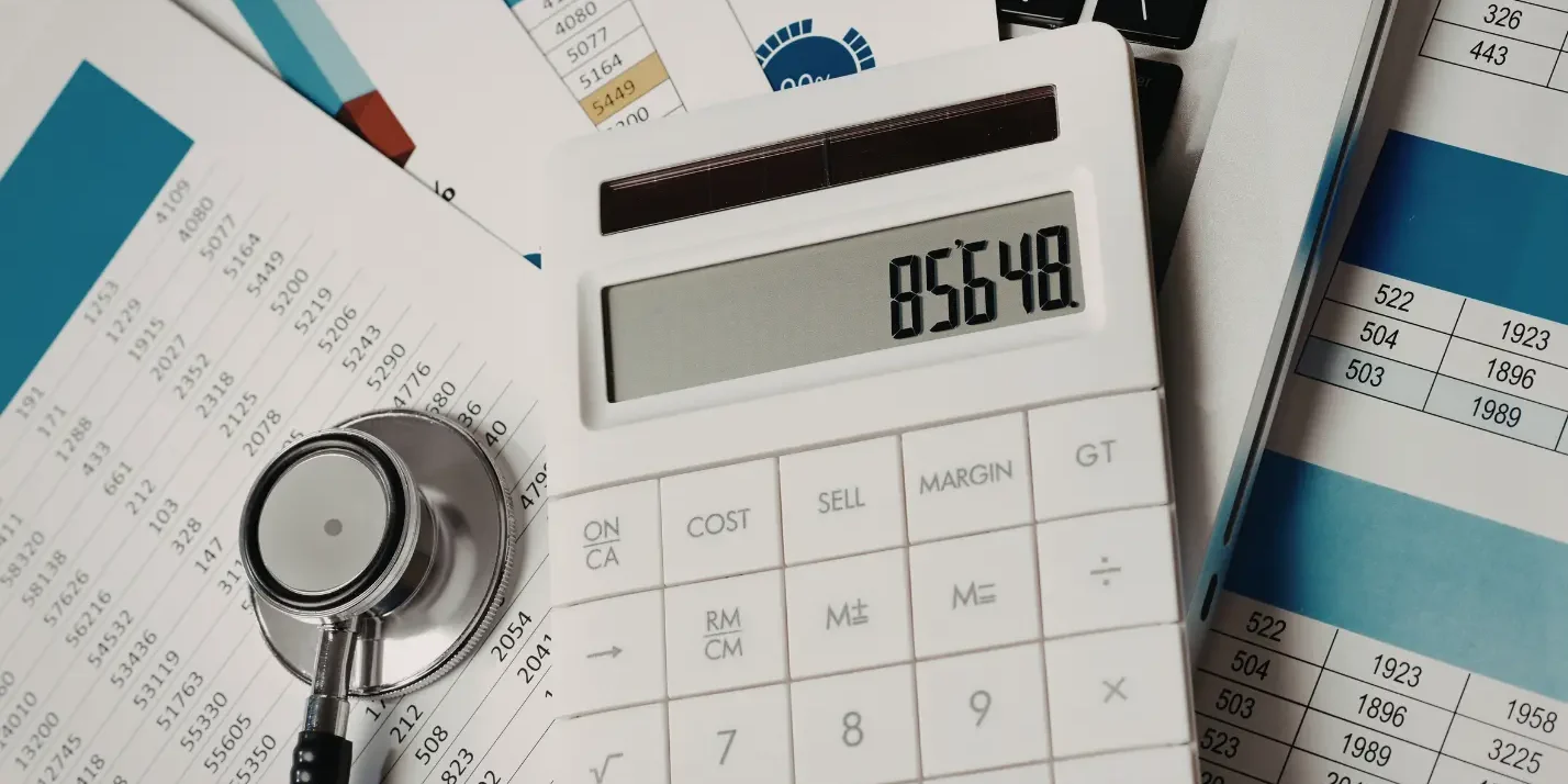 Healthcare billing paperwork and calculator showing medical billing cost