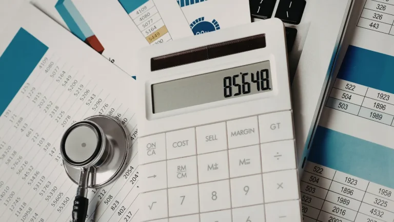 Healthcare billing paperwork and calculator showing medical billing cost