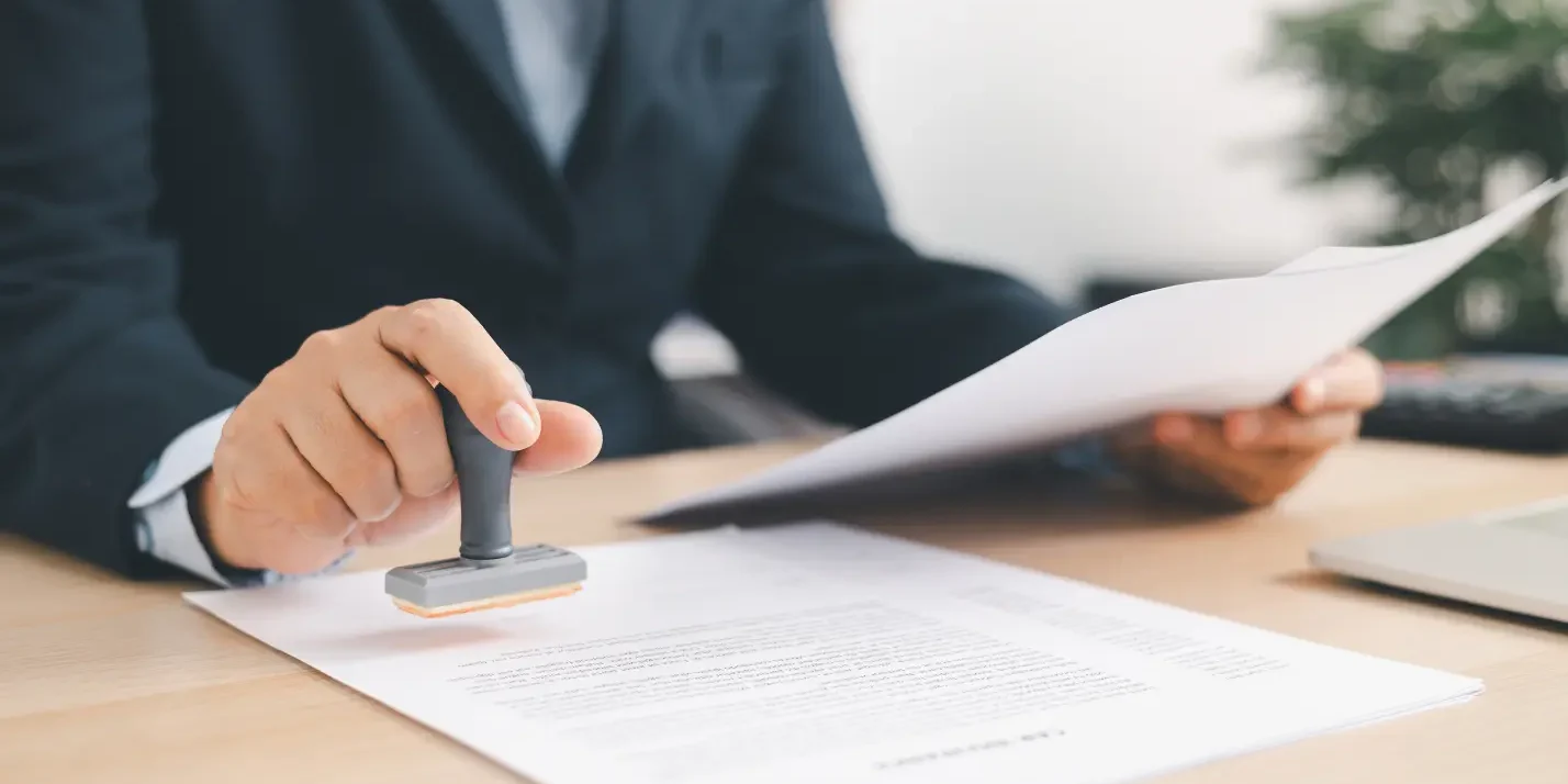 Healthcare professional reviewing and stamping prior authorization documents