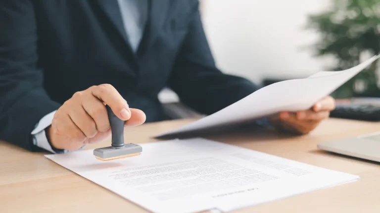 Healthcare professional reviewing and stamping prior authorization documents